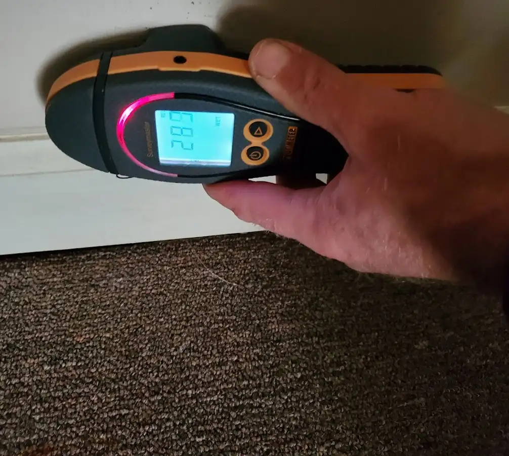 Moisture detection at baseboard during Storm Damage Restoration in East End